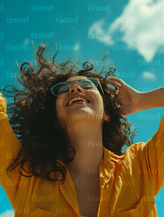 tinted-person-blowing-on-hair-and-smiling-with-hands-in-sky-b1a65729ef20